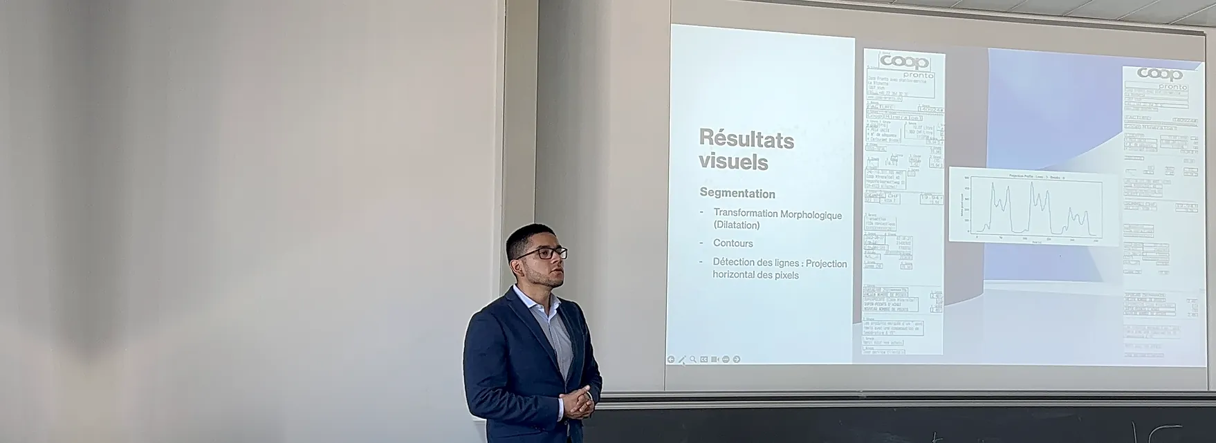 Jossef Roncal presenting his master's thesis in front of a projection screen