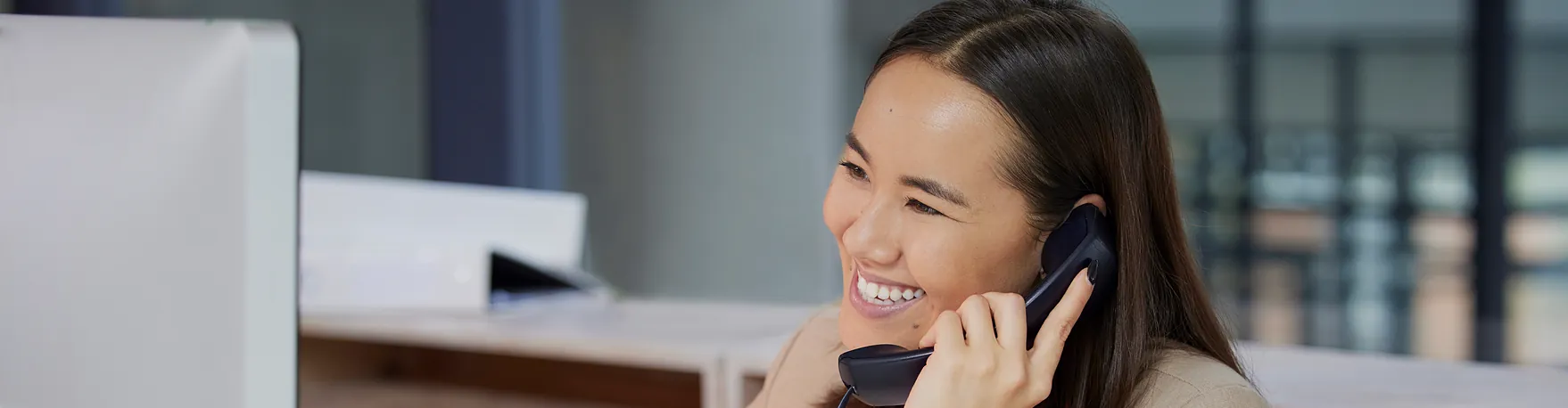 Una asesora sonriente responde al teléfono